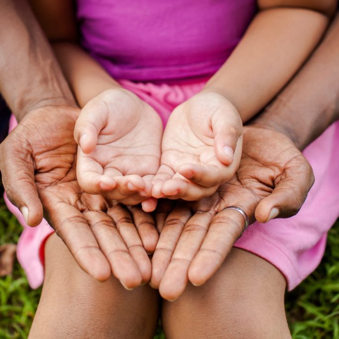Hands of family together in green park - family unity and peace concept